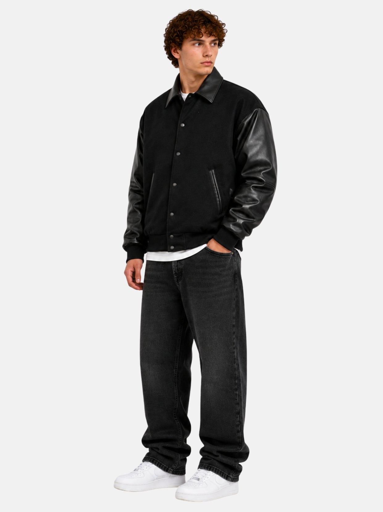 Full-length view of an all-black letterman jacket with leather sleeves and black jeans