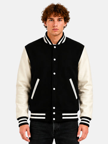 Man wearing a black and white varsity jacket with striped rib trims and white snaps