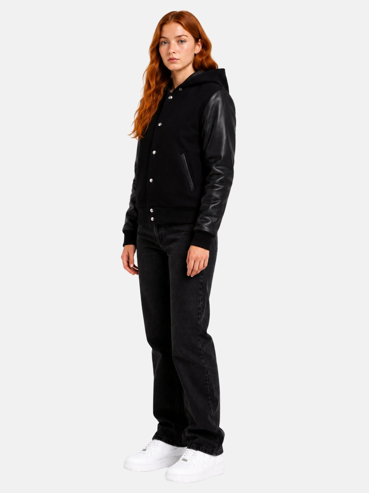 Full-length view of female model in black hooded varsity jacket with dark jeans