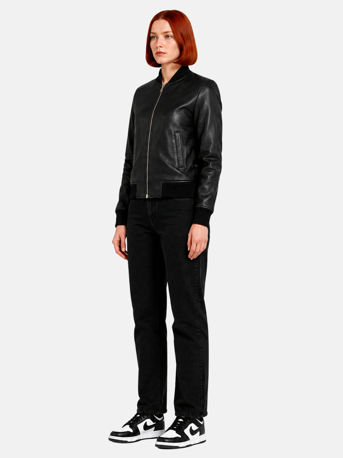Full-length view of black leather bomber-style varsity jacket over black denim