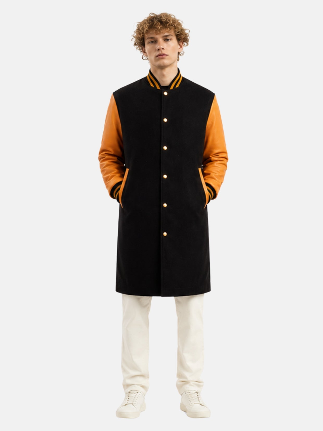 Man wearing knee-length black wool varsity coat with orange leather sleeves and gold snaps