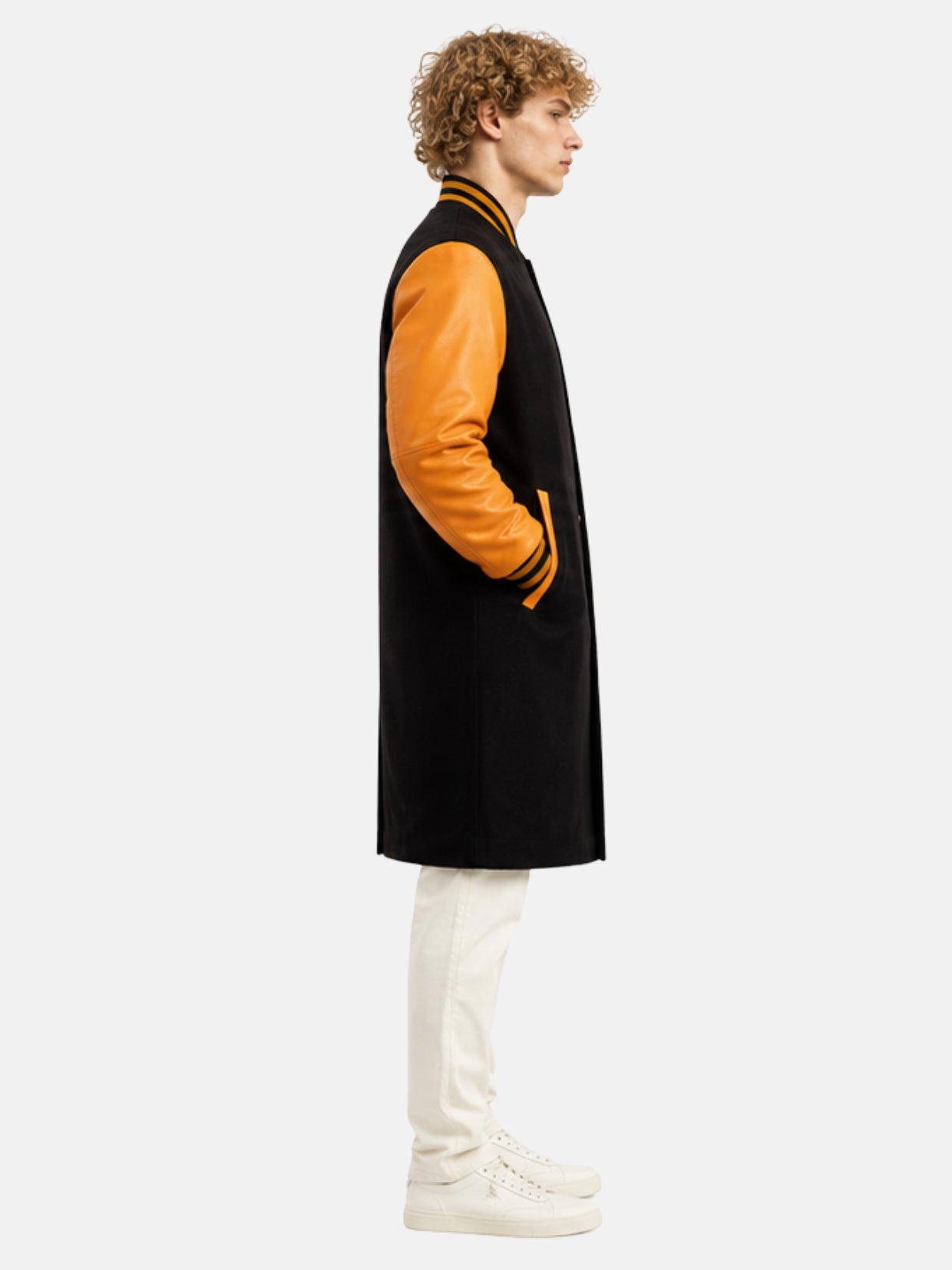 Side profile of black and orange varsity coat showing leather sleeve and striped cuff