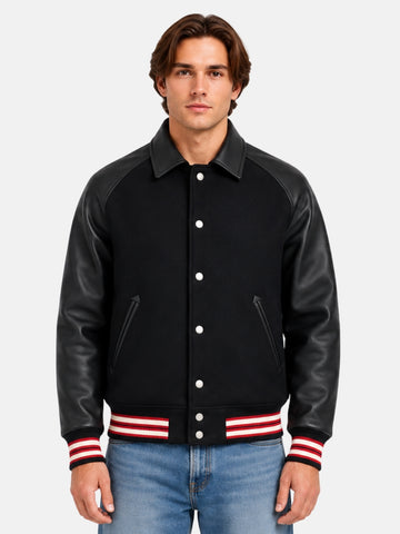 Man wearing collared black varsity jacket with leather raglan sleeves and red striped trims