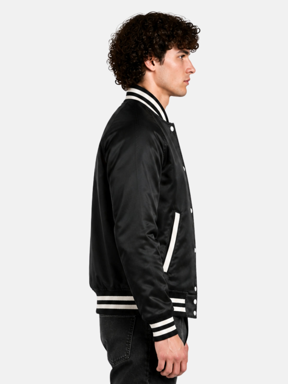 Side profile of a black satin raglan varsity jacket with cream-piped welt pocket