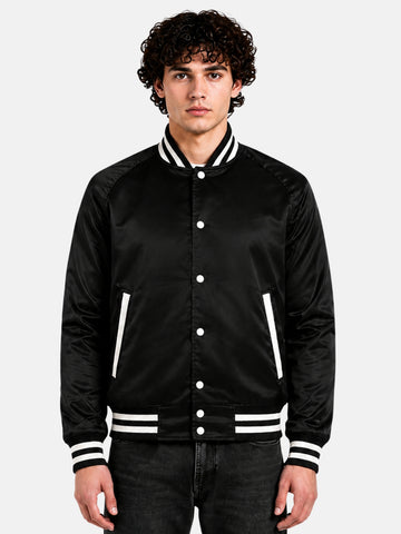 Man wearing a black satin varsity jacket with raglan sleeves and cream striped trims