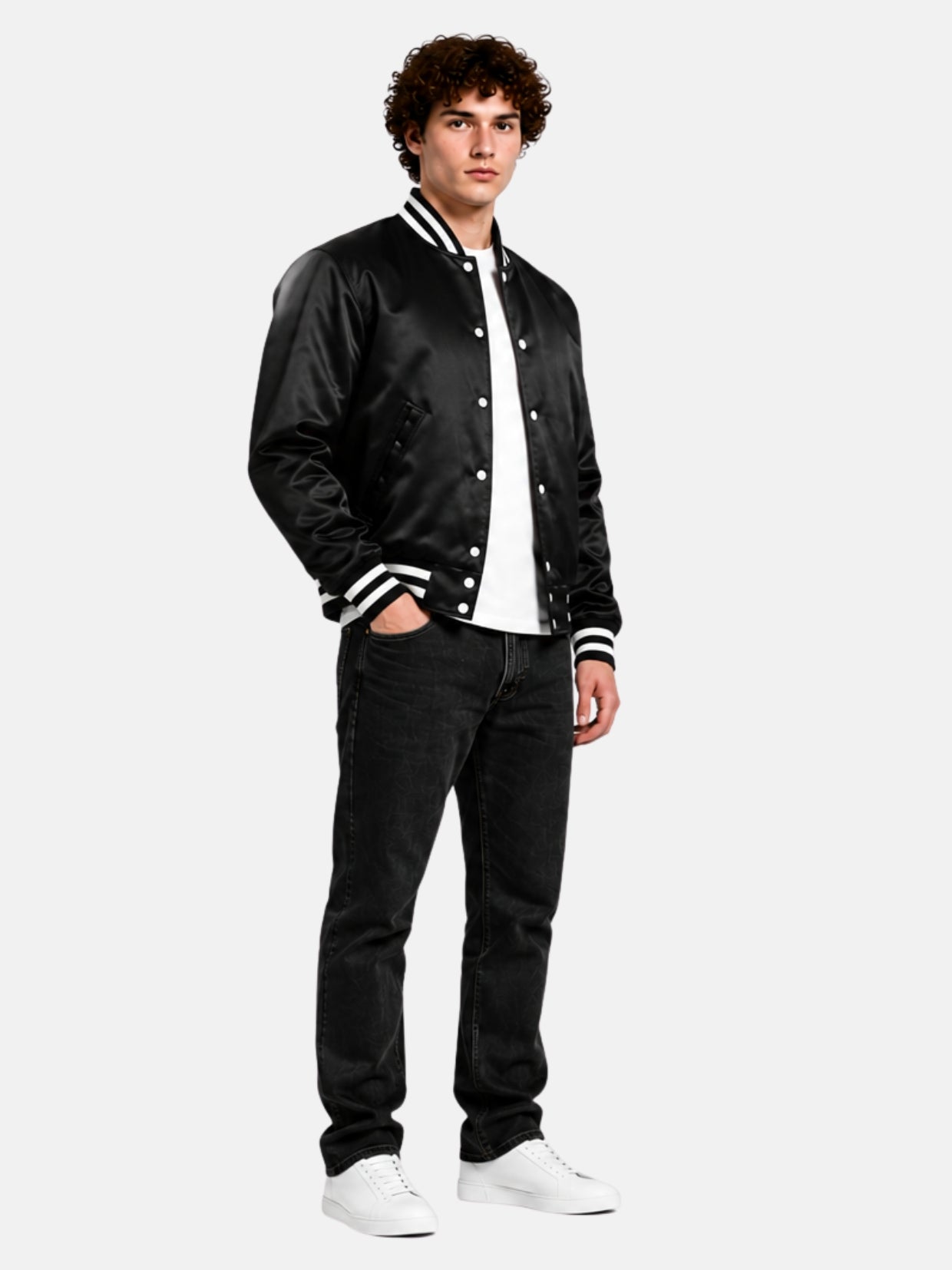 Full-length view of a black satin varsity jacket with black jeans and white sneakers