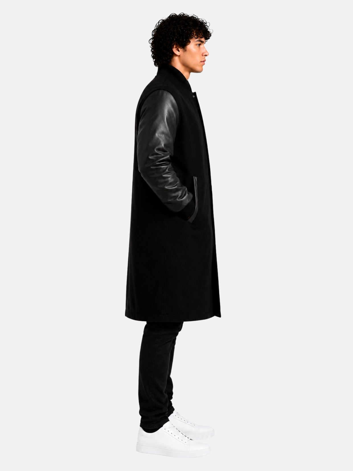 Side profile of black varsity coat showing leather sleeve and ribbed knit cuff