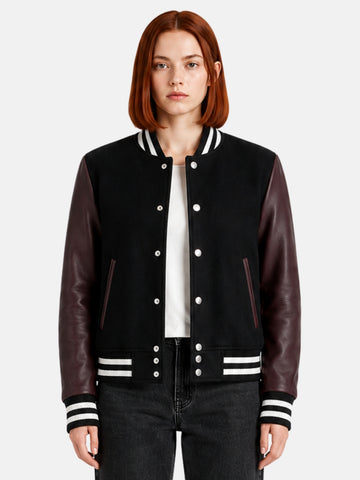 Woman wearing a black varsity jacket with burgundy leather sleeves and striped trims