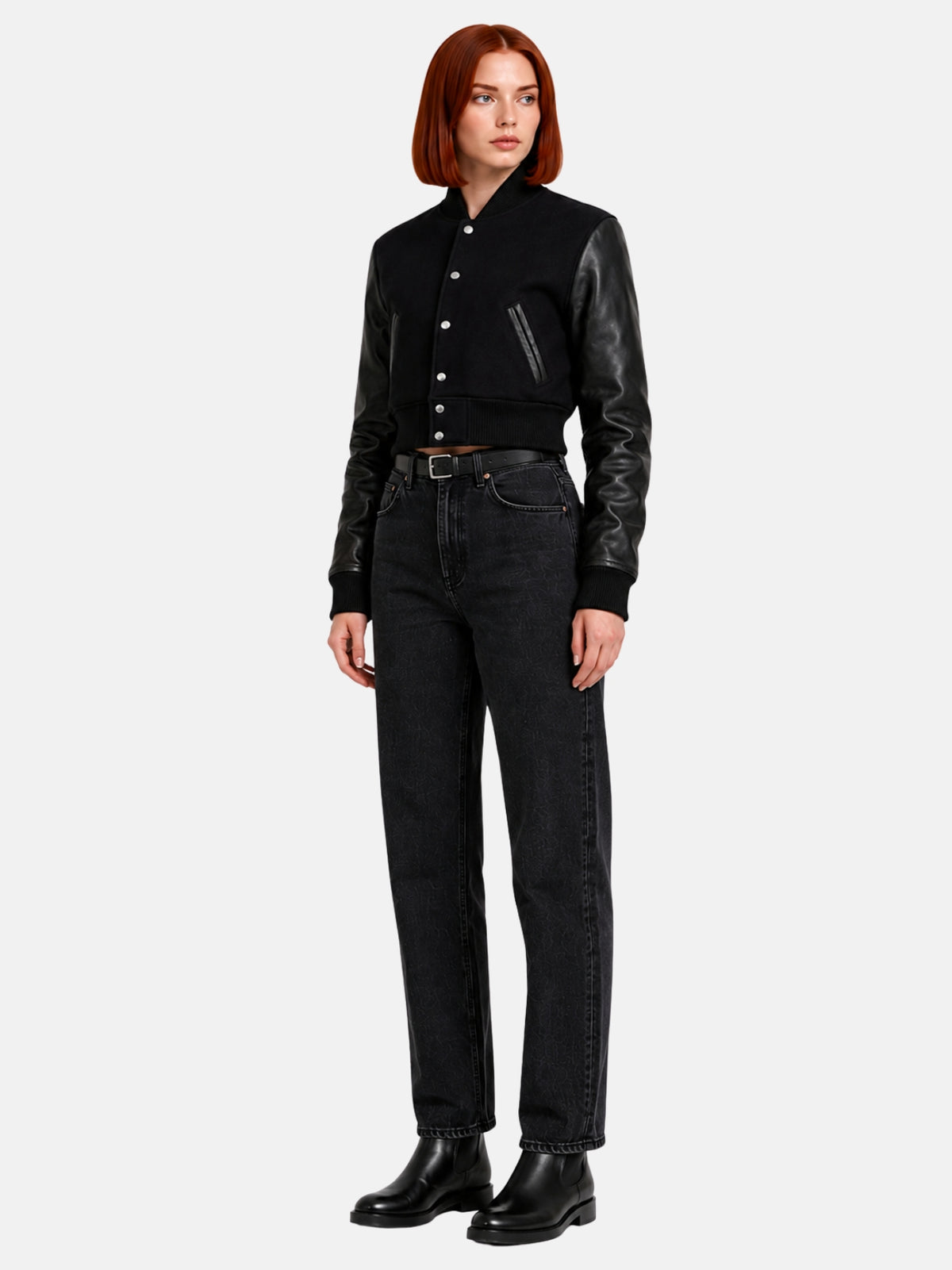 Full-length view of black leather-sleeve varsity jacket cropped above high-rise black jeans