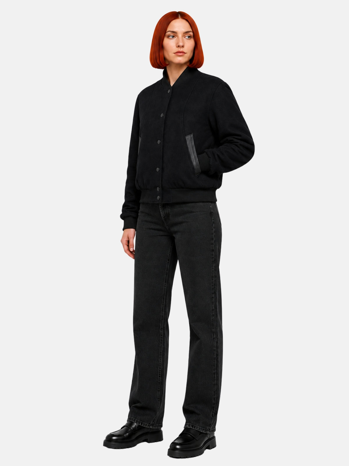 Full-length view of fitted black wool letterman jacket over black denim