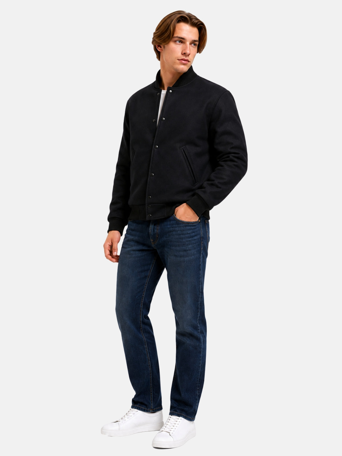 Full-length view of model in minimalist black wool varsity jacket with dark denim