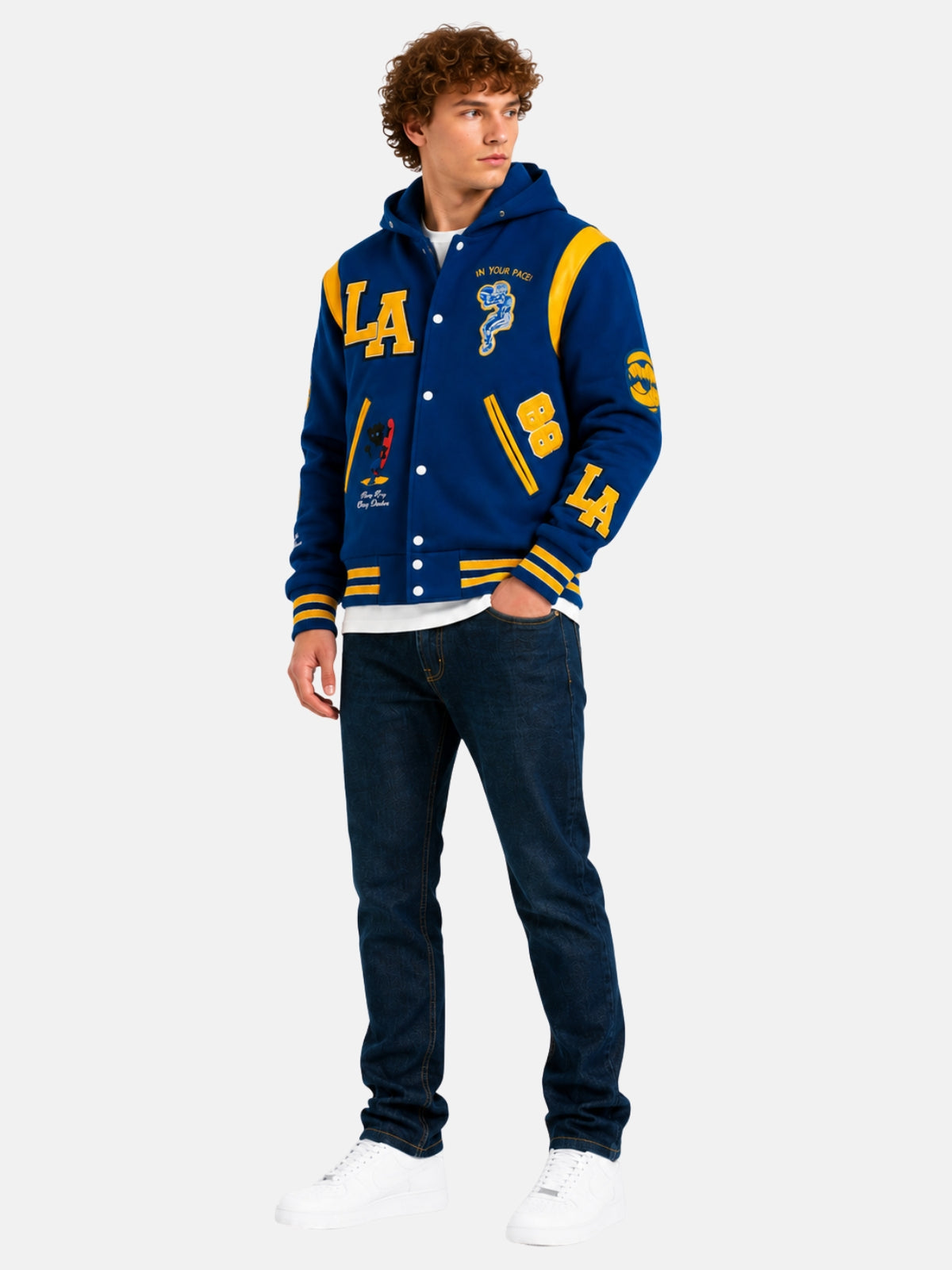 Full-length view of model in royal blue hooded varsity jacket with dark denim