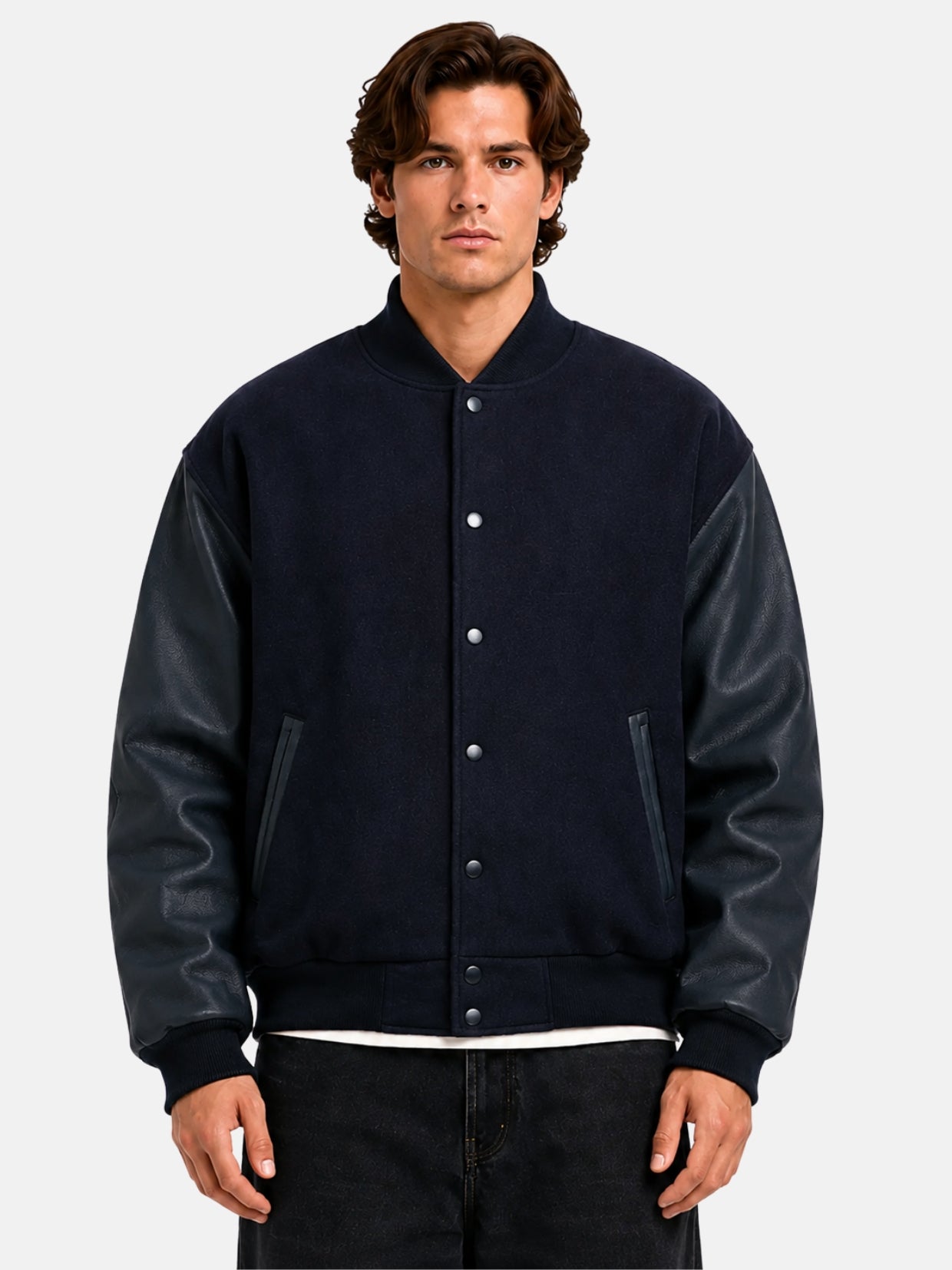 Man wearing a navy blue varsity jacket with leather sleeves and tonal snap front