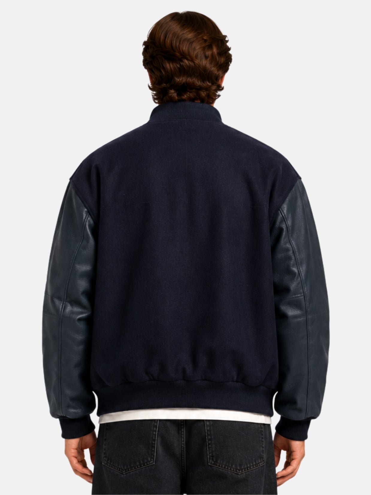 Back view of a blue wool varsity jacket with navy leather sleeves on model