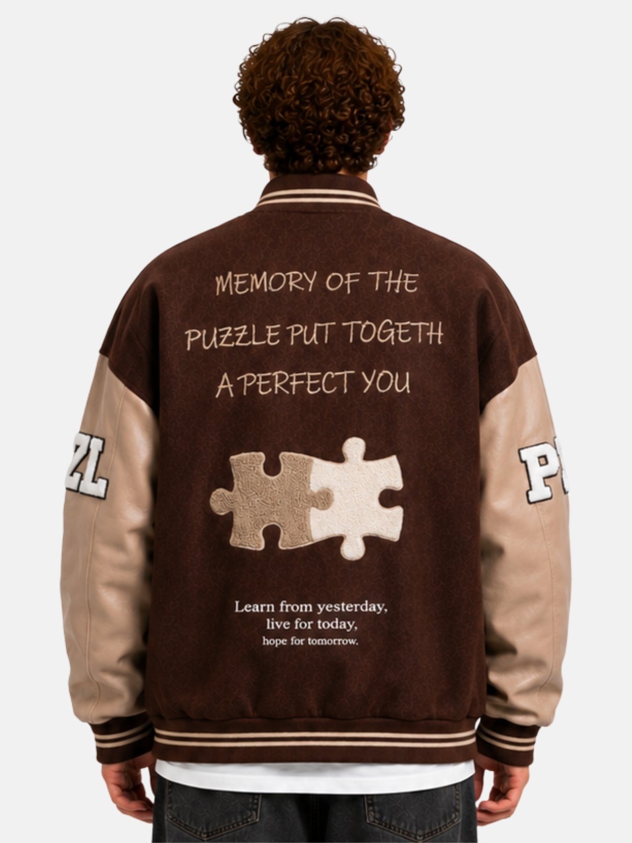 Back view of a brown varsity jacket with puzzle patch and embroidered lettering on model