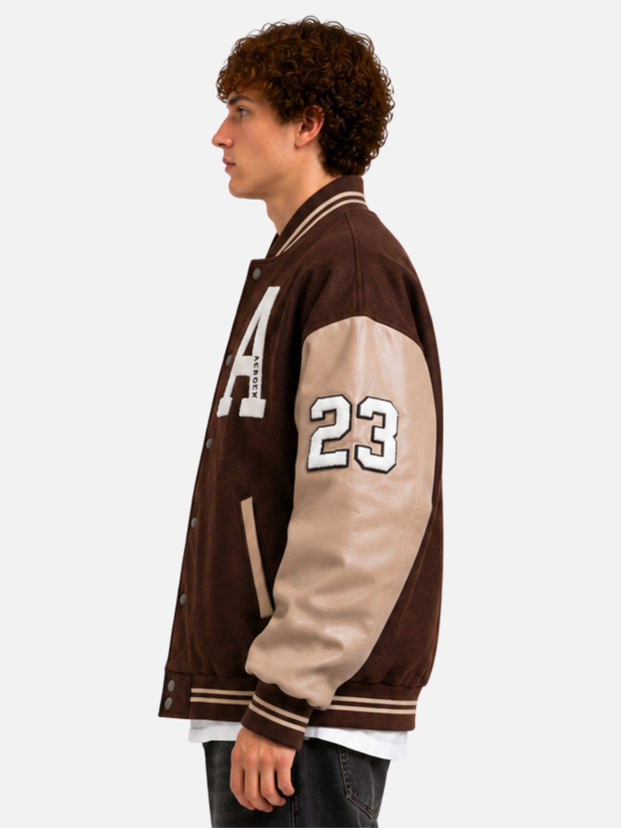 Side profile of a brown varsity jacket with cream leather sleeves and 23 number patch