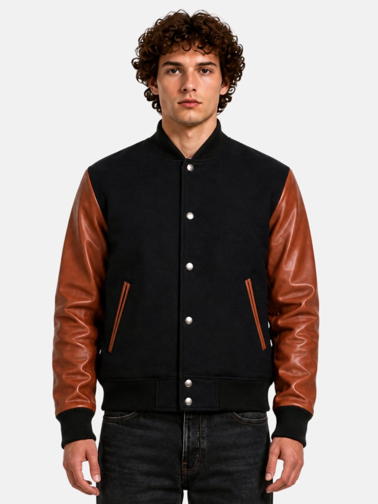 Man wearing black varsity jacket with brown leather sleeves and silver snaps, front view
