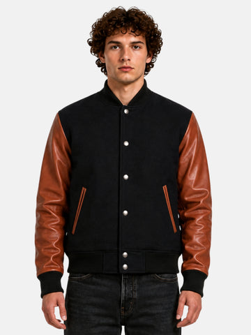Man wearing black varsity jacket with brown leather sleeves and silver snaps, front view