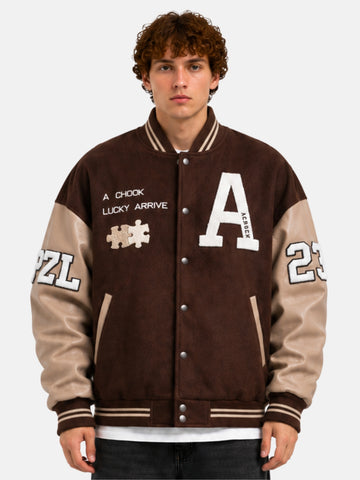 Man wearing a brown varsity jacket with chenille A patch, puzzle motif and cream leather sleeves