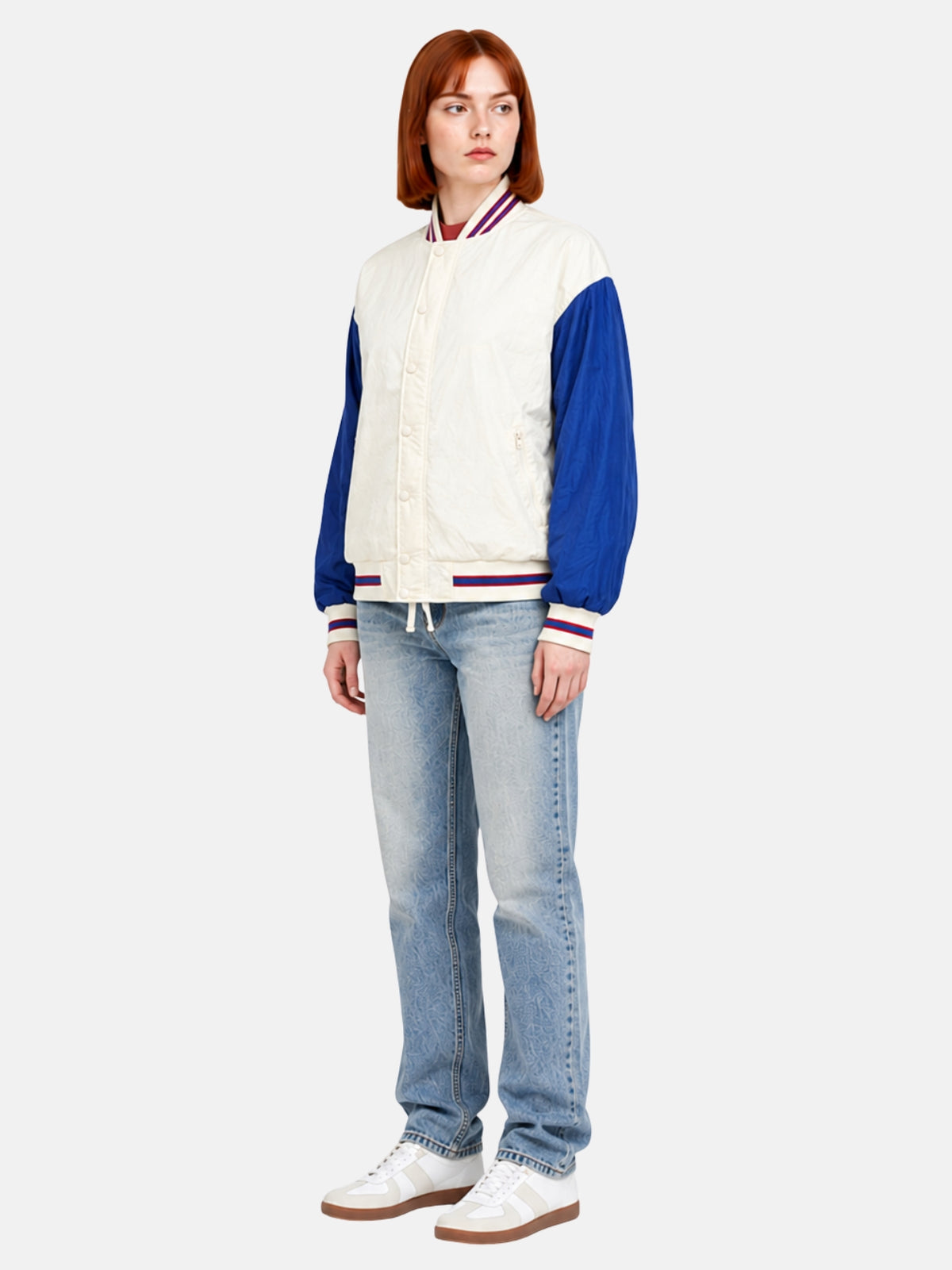 Angled full-body view of cream and blue windbreaker varsity jacket
