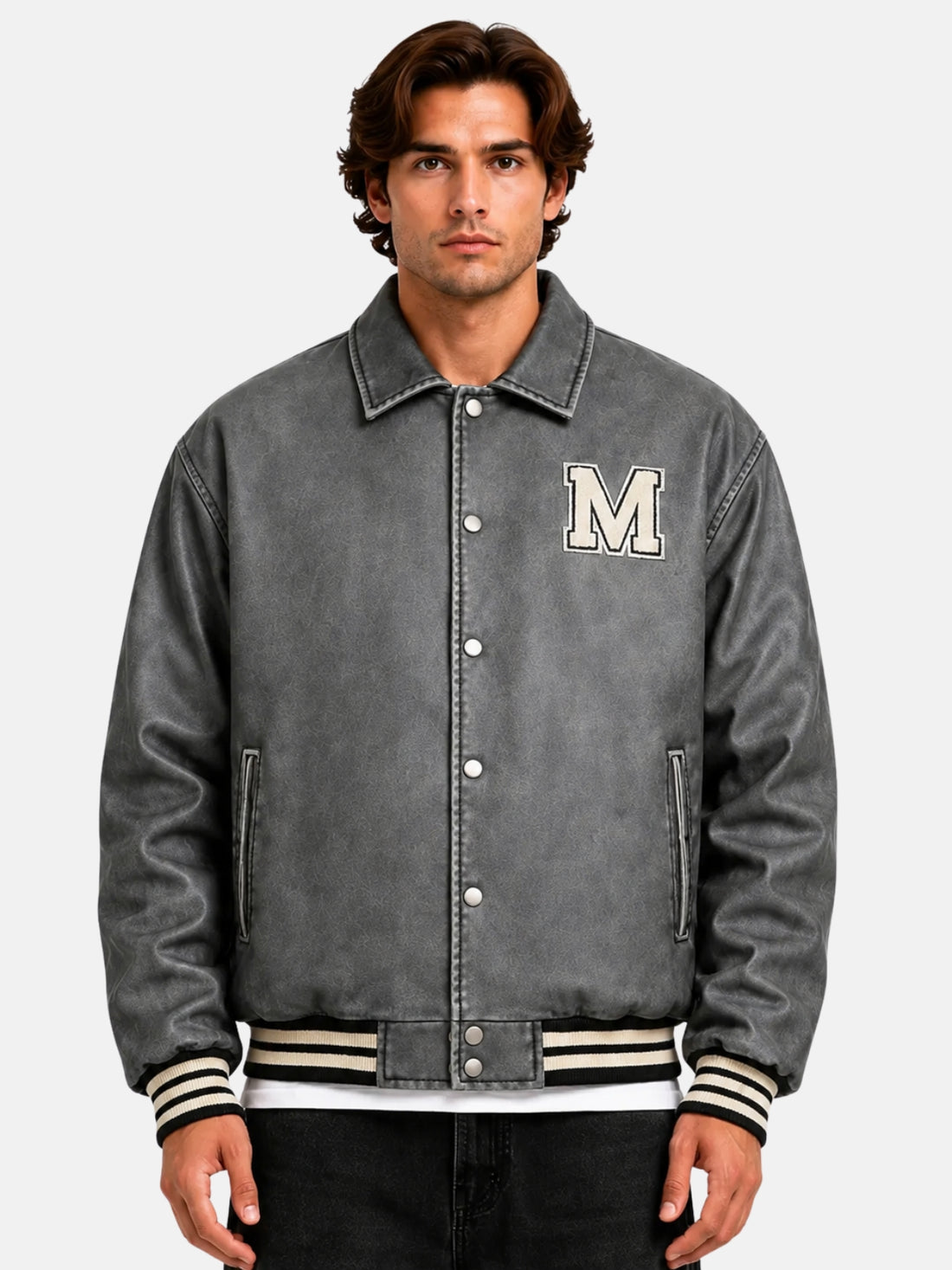 Man wearing a distressed grey leather varsity jacket with chenille M patch and snap front