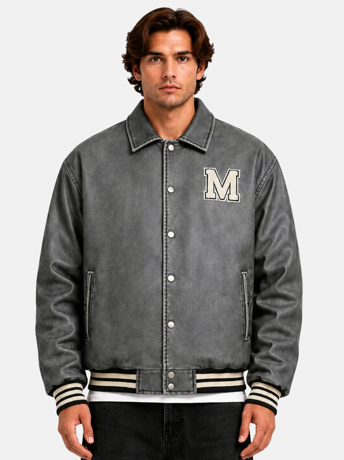 Man wearing a distressed grey leather varsity jacket with chenille M patch and snap front