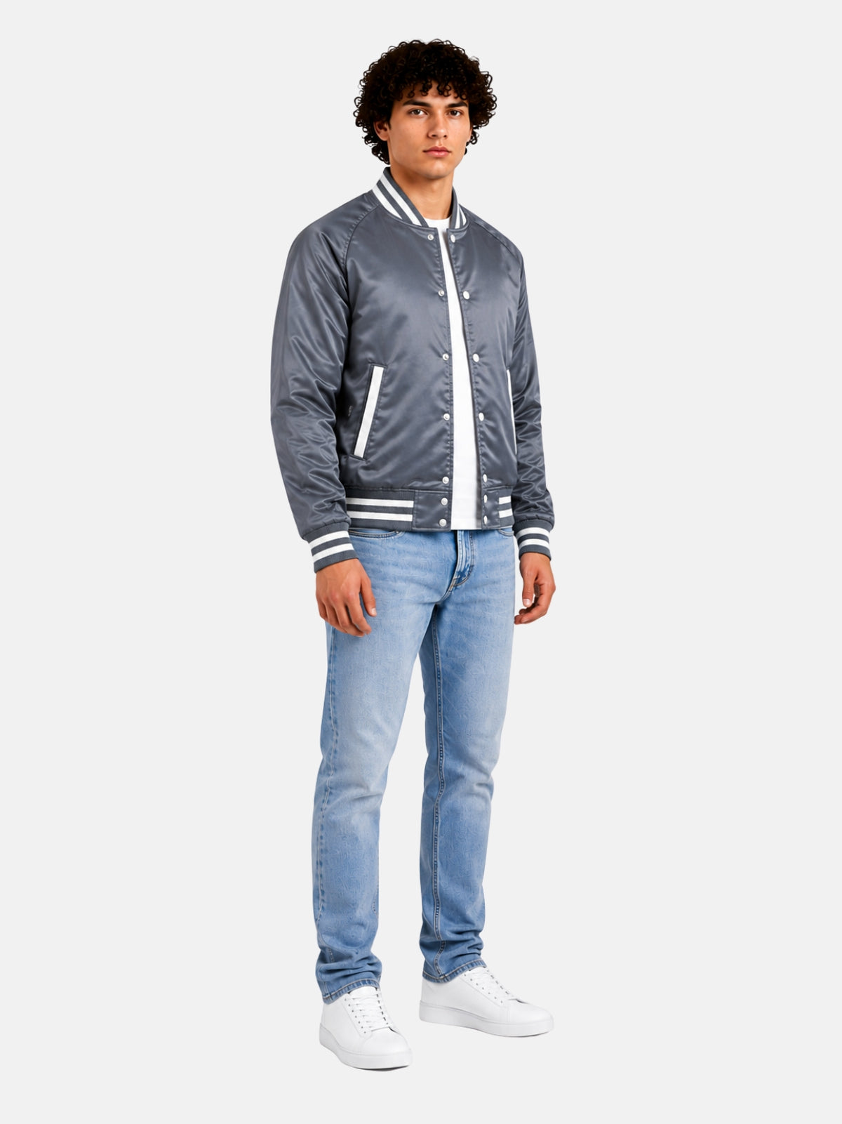 Full-length view of model in slate grey satin varsity jacket with light-wash jeans