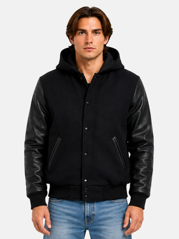 Man wearing black hooded varsity jacket with leather sleeves and matte snaps, size Medium