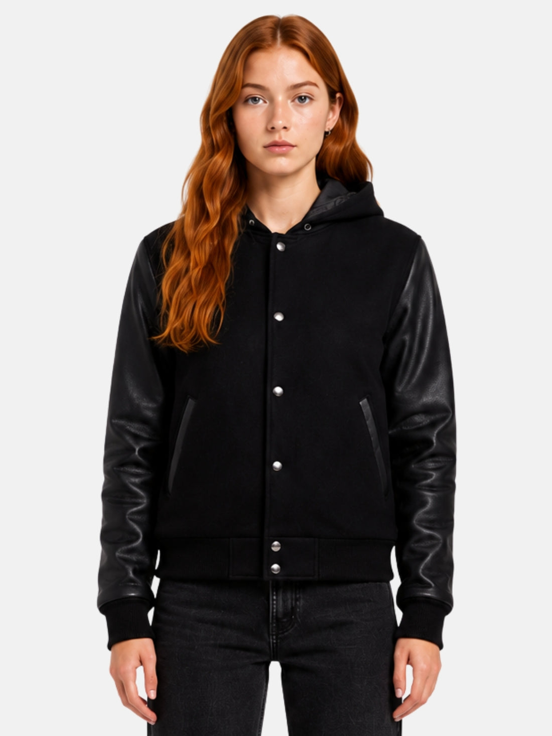 Woman wearing a black hooded varsity jacket with leather sleeves and hood up