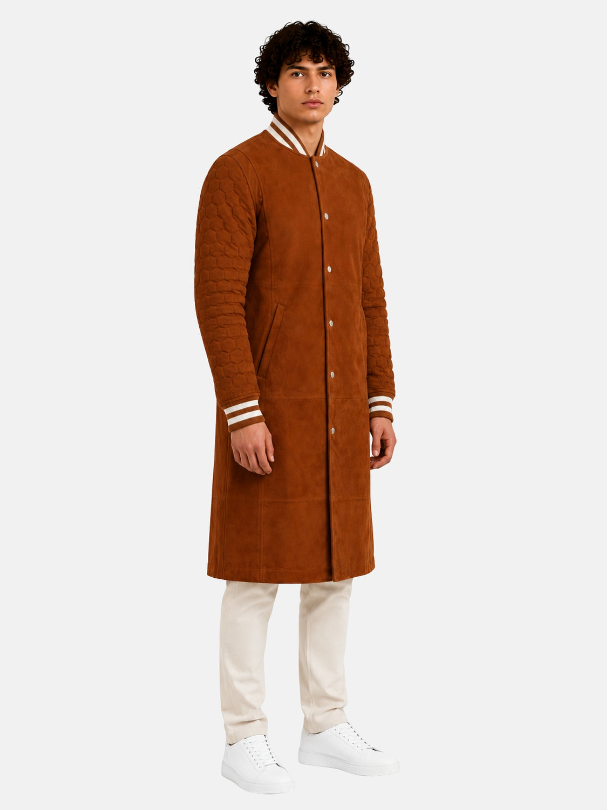Model in long tan varsity coat with honeycomb-quilted sleeves and cream striped trims