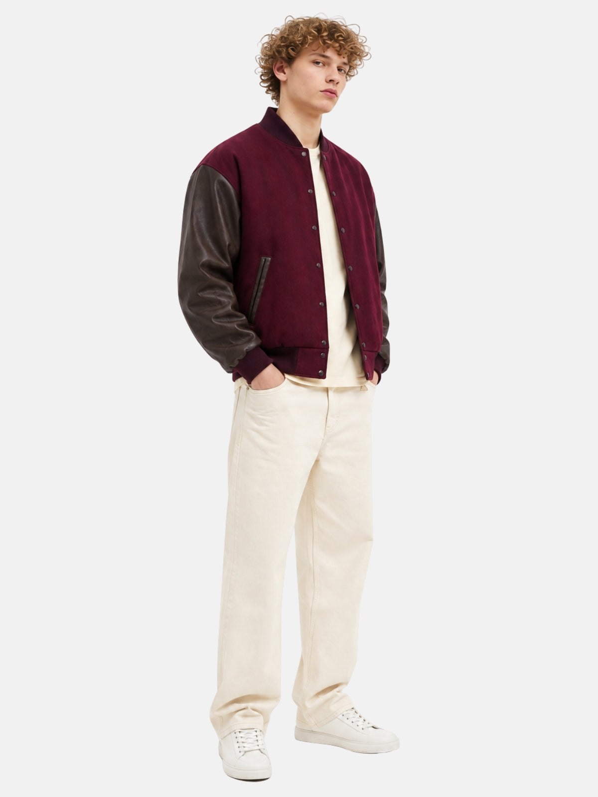 Full-length view of a maroon letterman jacket with brown leather sleeves and cream pants