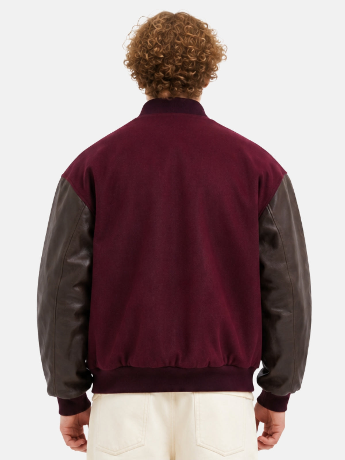 Back view of a maroon wool varsity jacket with brown leather sleeves on model