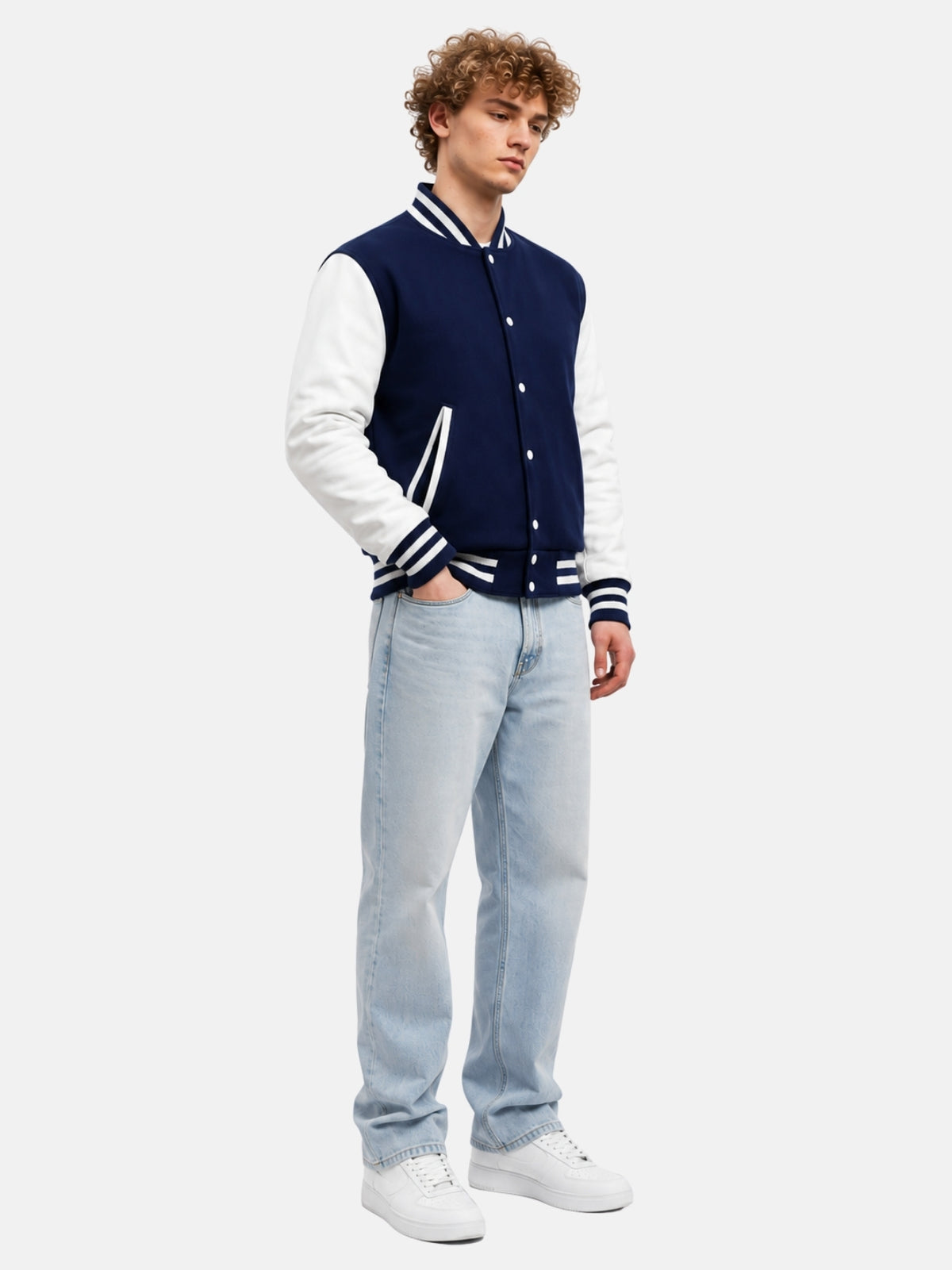 Full-length outfit with navy letterman jacket, light-wash jeans and white sneakers