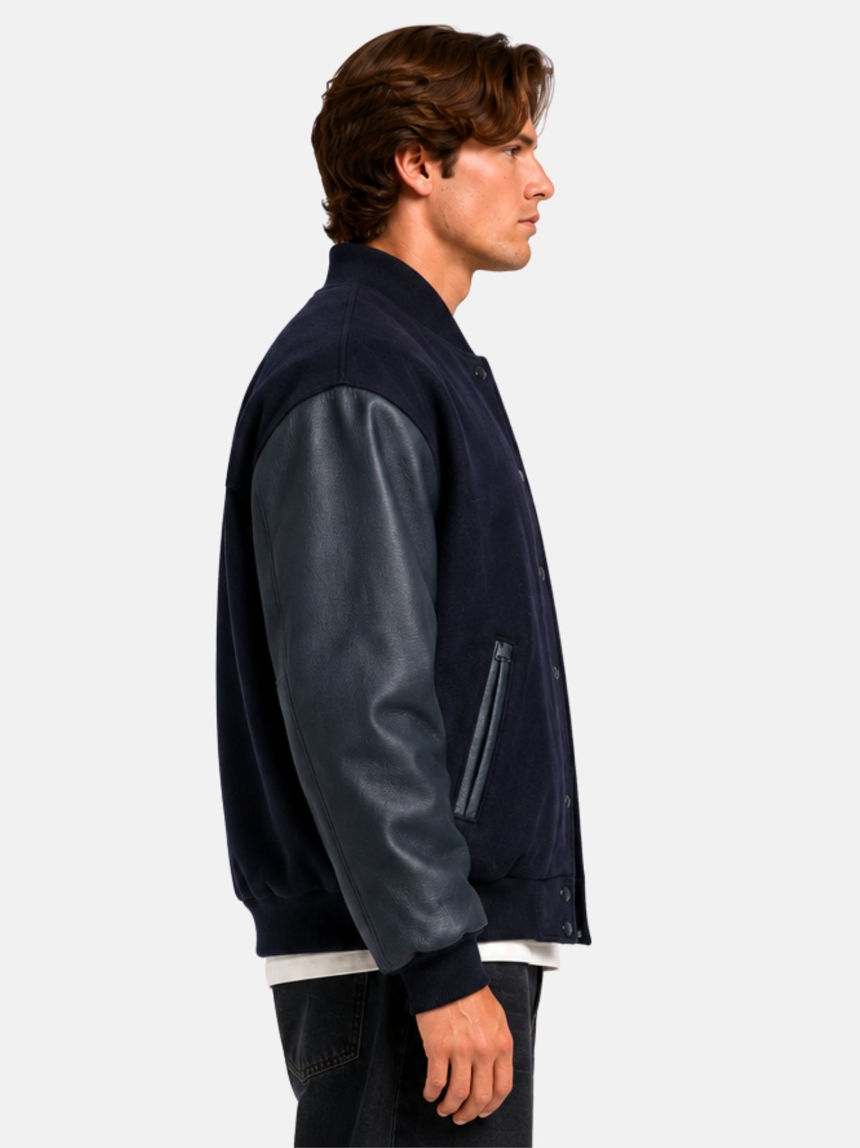 Side profile of a navy blue letterman jacket with pebbled leather sleeves on model
