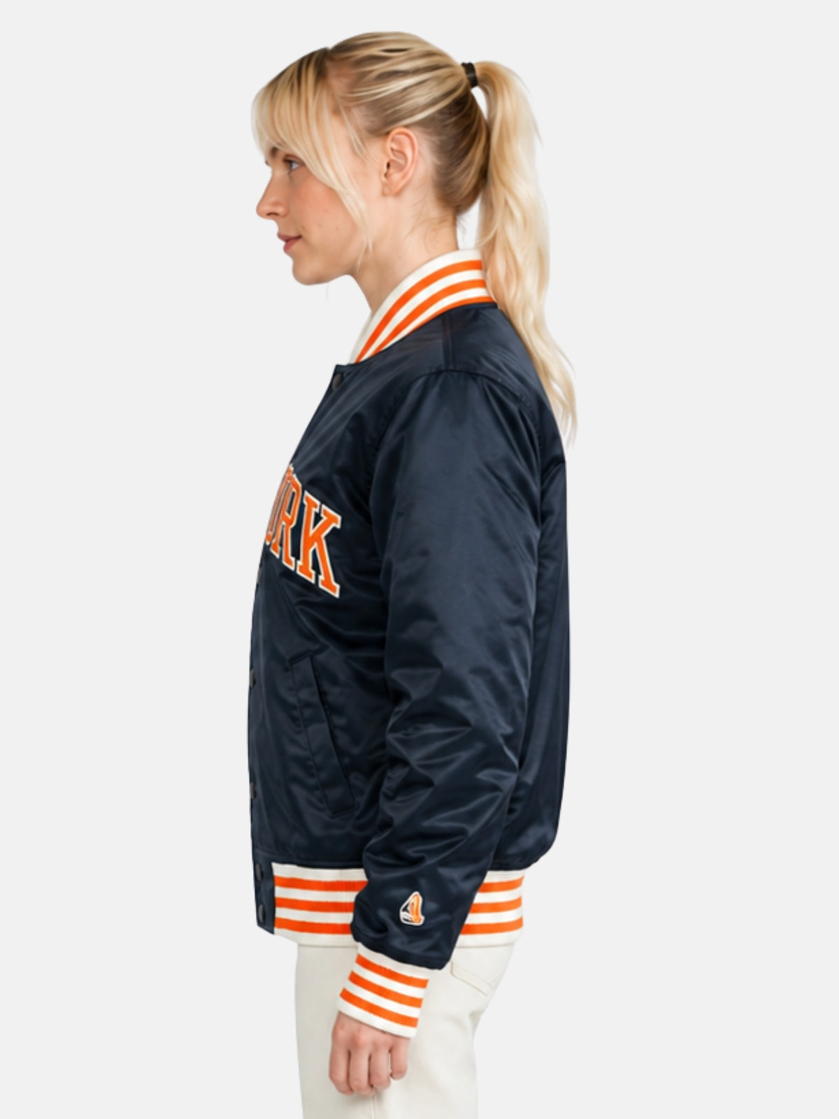 Side profile of navy satin jacket showing sleeve logo patch