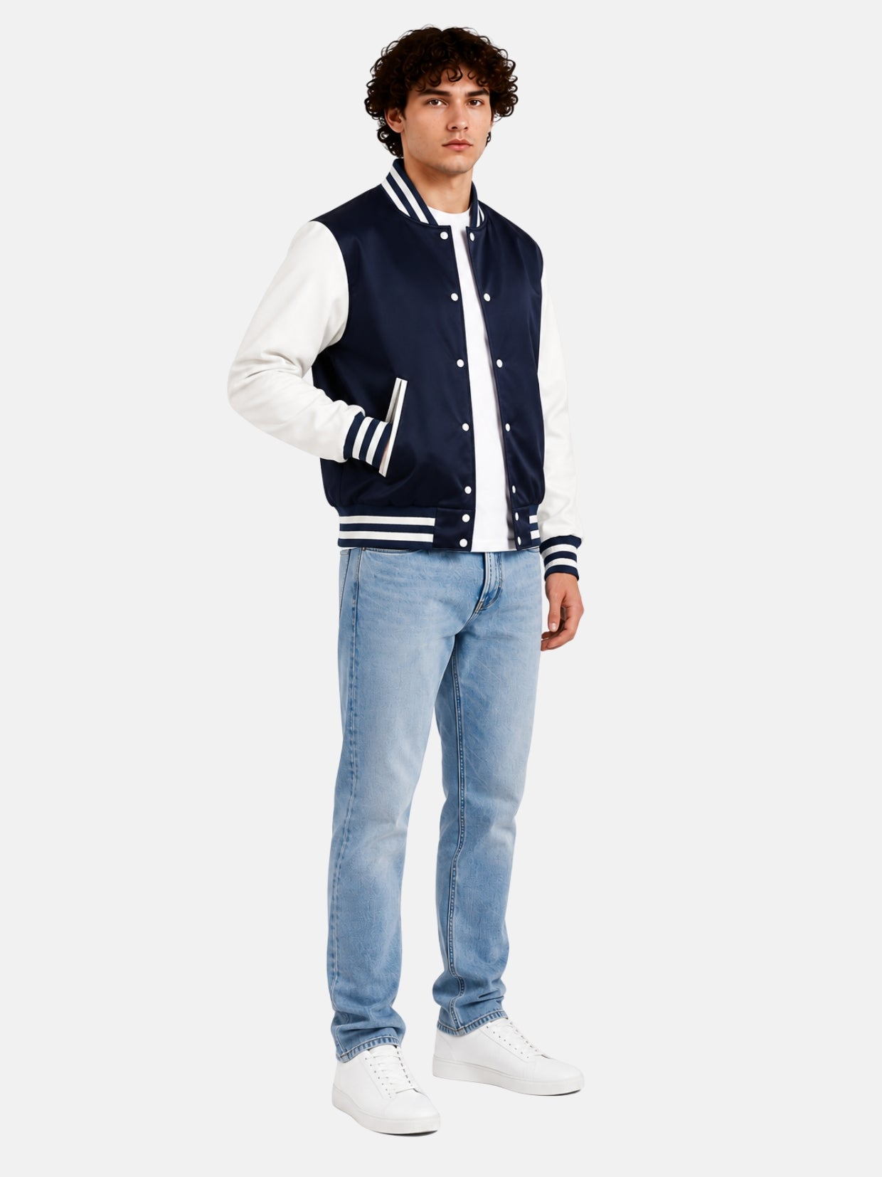 Full-length view of model in navy and white satin varsity jacket with light-wash jeans