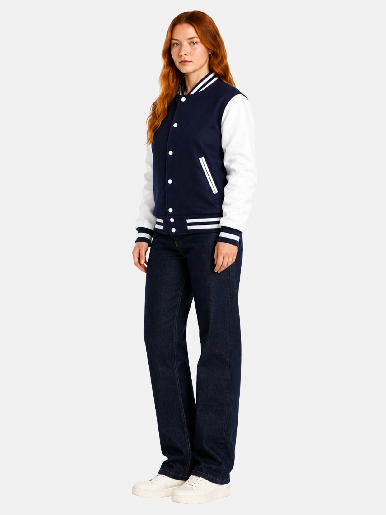 Full-length view of female model in navy and white varsity jacket with dark denim