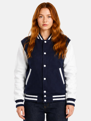 Woman wearing a navy varsity jacket with white leather sleeves and striped rib trims