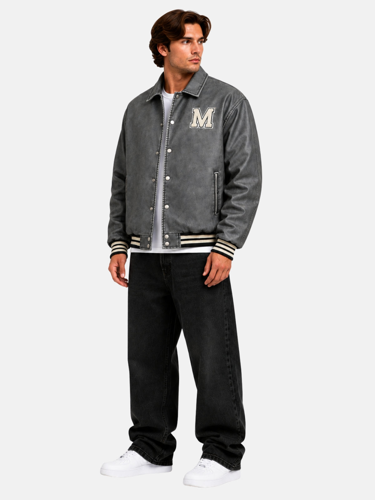 Full-length view of an oversized washed grey leather varsity jacket with black jeans