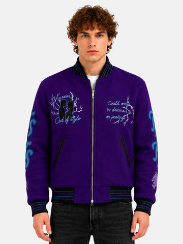 Man wearing a purple embroidered varsity jacket with script lettering and zip front