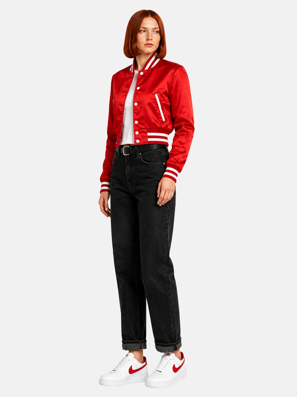 Full-body three-quarter shot of model walking in the red satin jacket, white-and-red sneakers and rolled black denim
