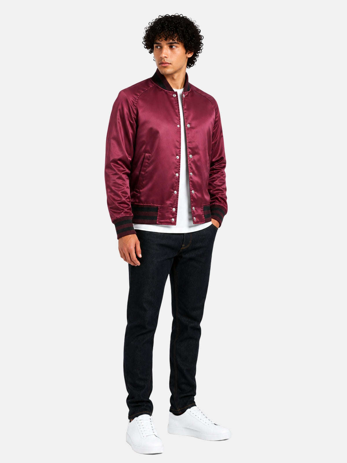 Full-length view of model in maroon satin varsity jacket with dark denim