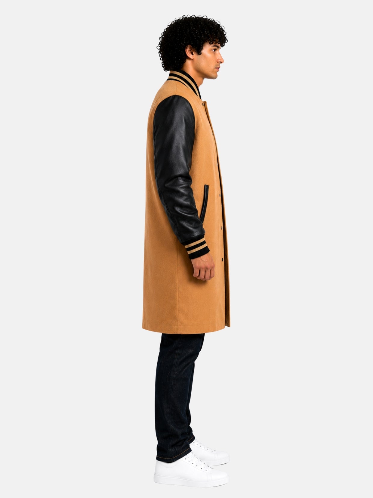 Side profile of tan and black varsity coat showing leather sleeve and gold-striped cuff