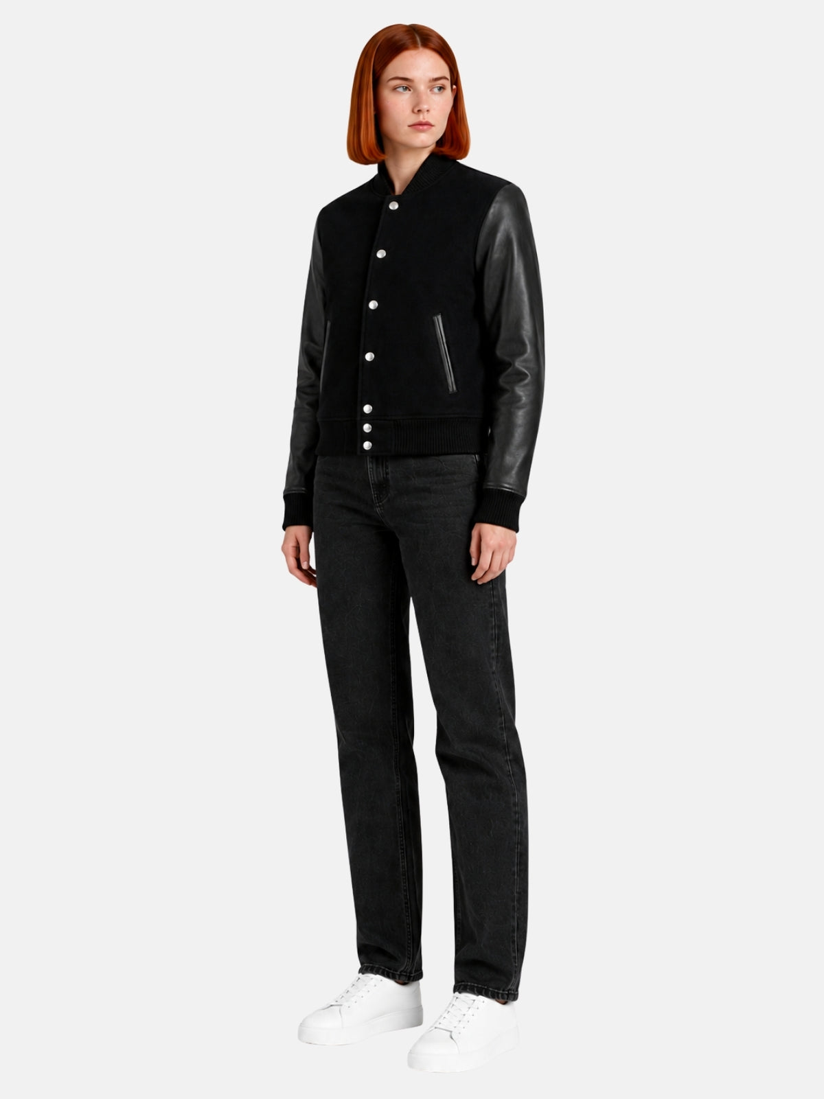 Full-length view of female model in all-black varsity jacket with black jeans