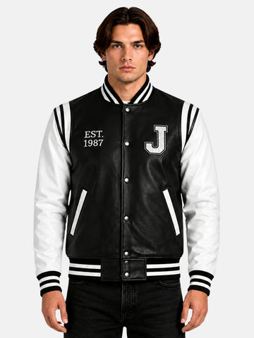 Man wearing black and white leather letterman jacket with chenille J patch and Est 1987 embroidery