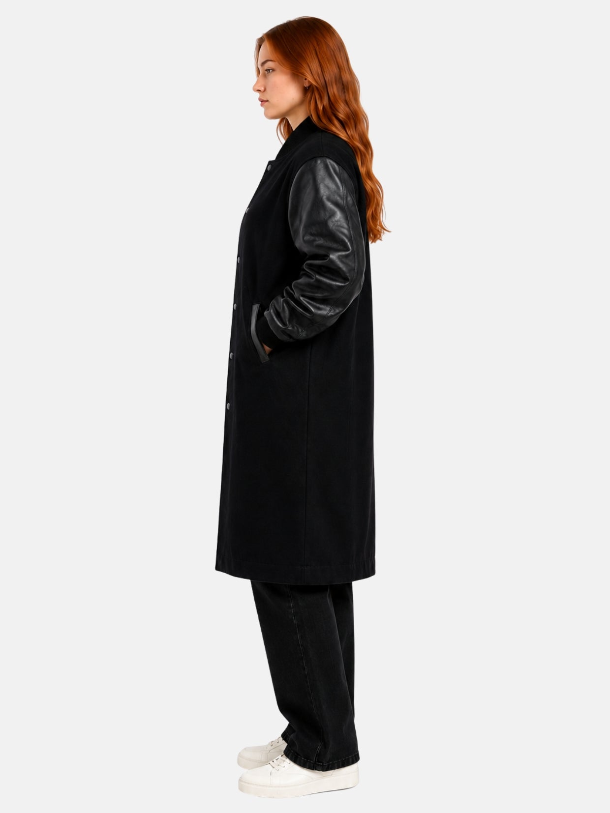 Side profile of black longline varsity coat showing leather sleeve and welt pocket