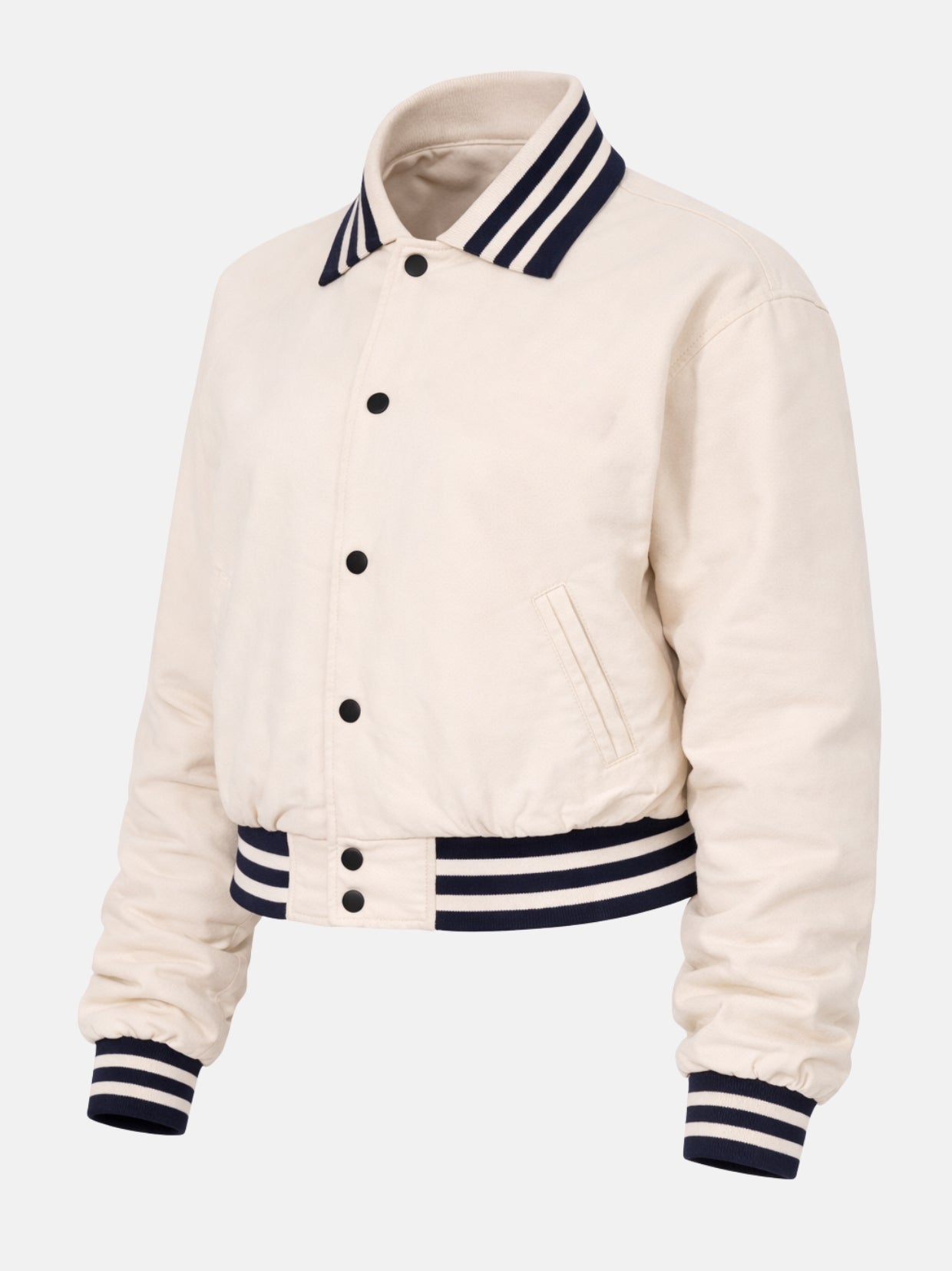 Women’s cream cotton varsity jacket with navy trim and ribbed cuffs, snap front, tilt view